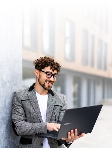 A man using ASUS ExpertBook B3 on one hand while on the go. 